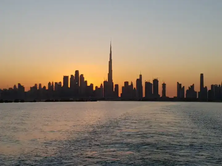 Dubai's skyline at sunset, the Burj Khalifa rising above the water